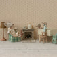Maileg's baby twin mice in matchbox beds add extra charm to a cozy miniature setting with a fireplace, teapot, lamp, and checkered furniture.