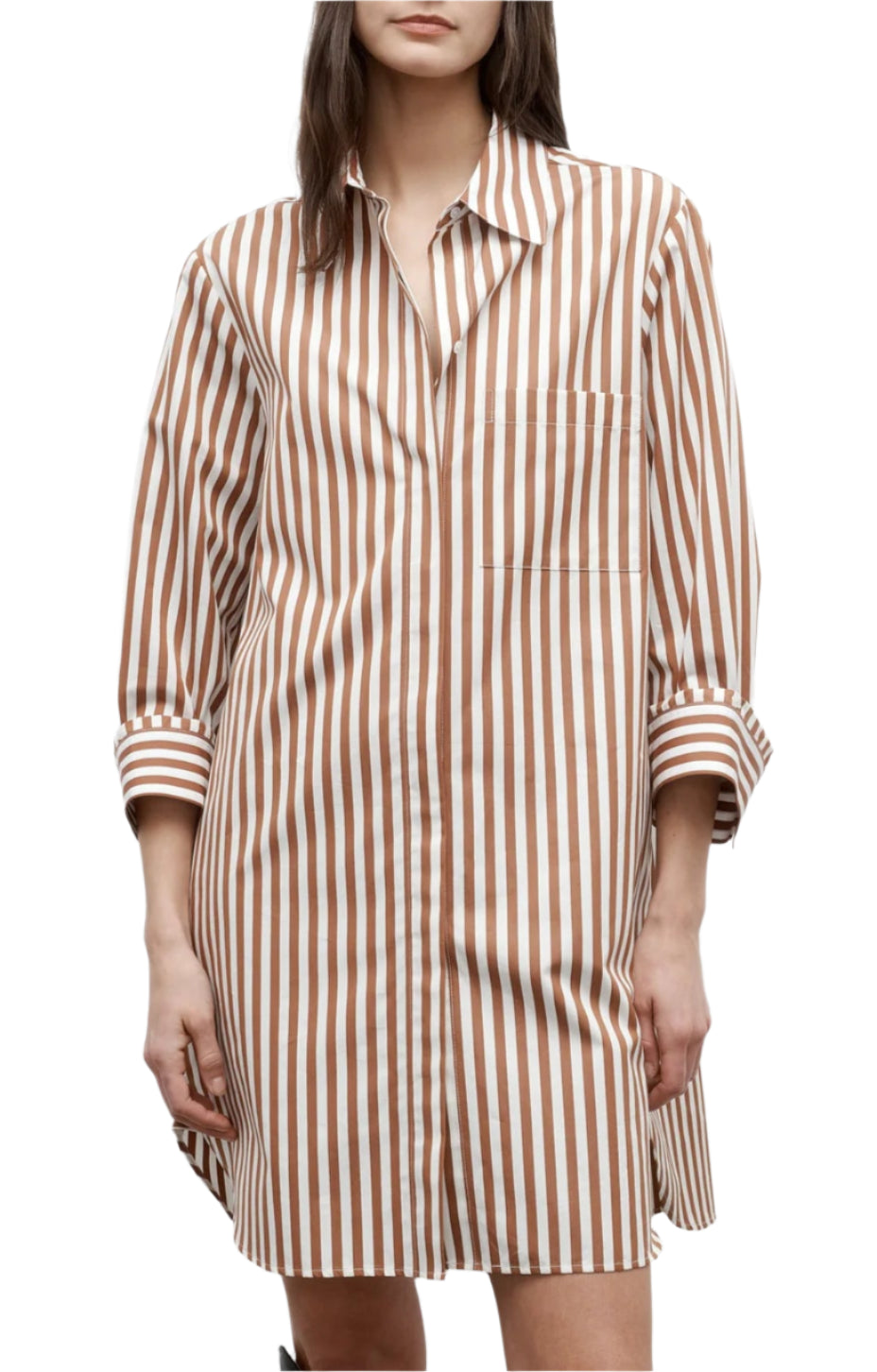 A woman wears the TWP Morning After Dress, featuring brown and white vertical stripes, long sleeves, a chest pocket, and a relaxed silhouette.