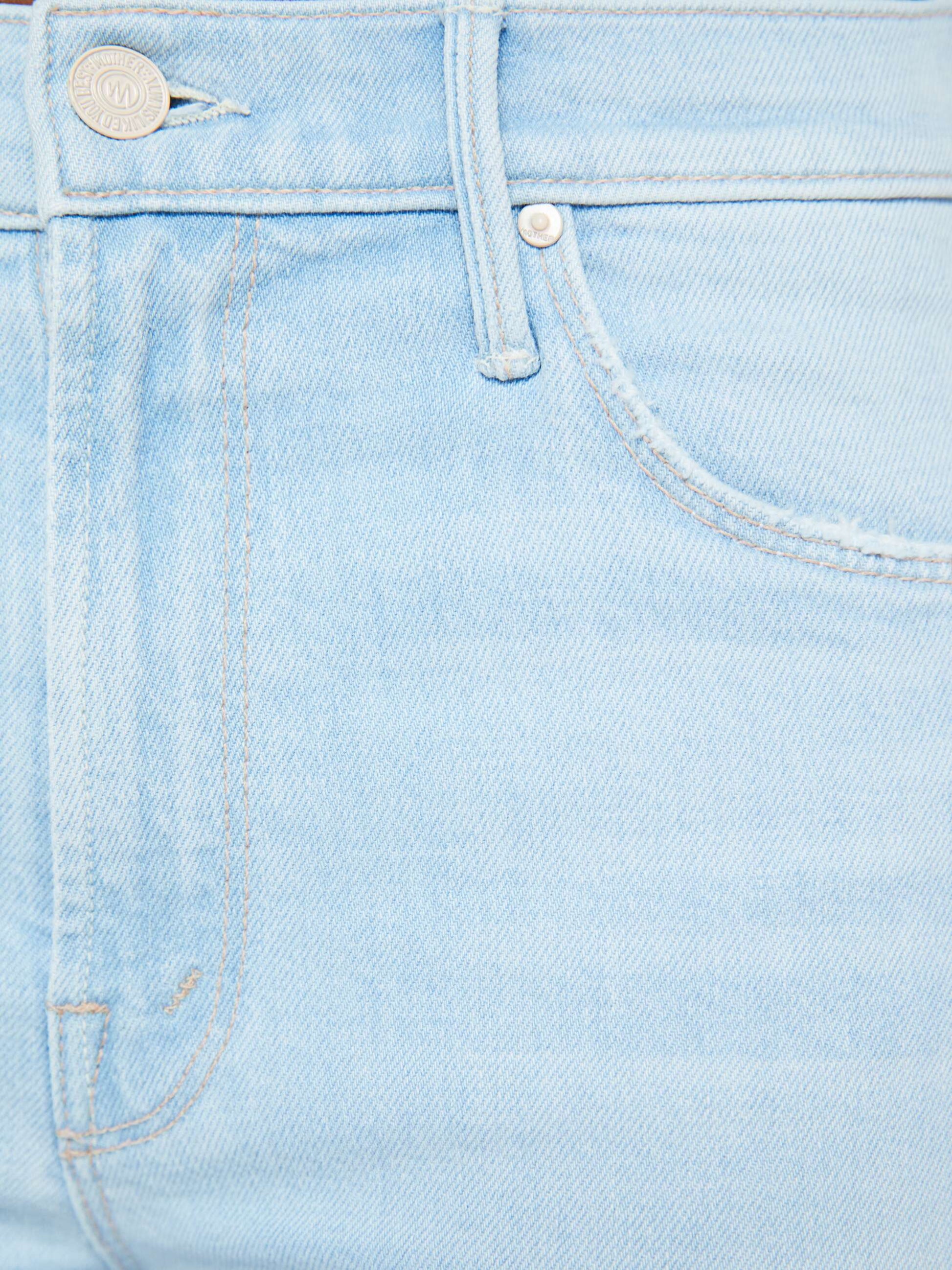 Close-up of the front pocket and button area of Mother’s The Mid Rise Dazzler Crop Fray, made from recycled stretch denim in a light blue wash.