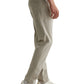 A person wearing AG Jeans Tellis Commuter Performance Airluxe Modern Slim pants in light beige, featuring a tapered leg, paired with white sneakers, is shown from the side against a plain white background.