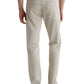 A person wearing AG Jeans Tellis AG-ed™ Modern Slim Denim in light beige and brown shoes, standing with their back to the camera.