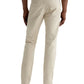 A person wearing AG Jeans' Tellis Modern Slim Sueded Stretch Sateen men's pants in light beige, paired with brown loafers, stands facing away from the camera against a plain background.