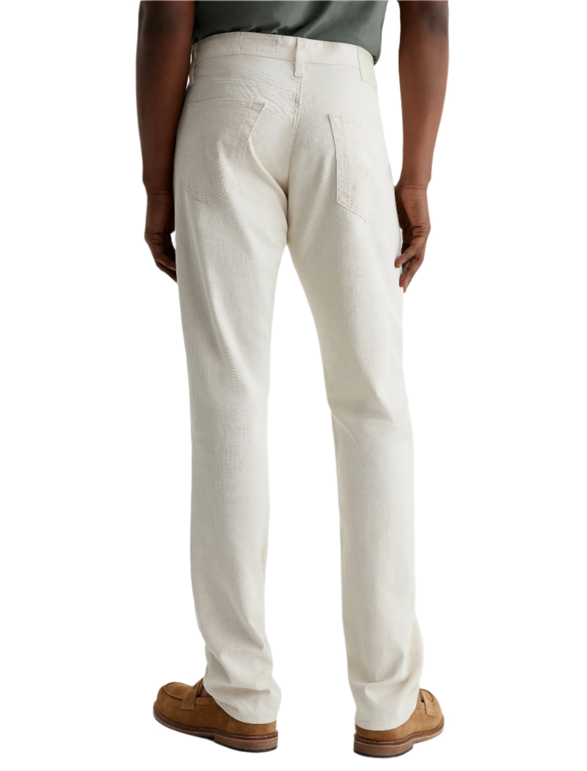 A person shown from the back wears AG Jeans Everett Slim Straight Leg men's pants in off-white cotton-linen twill with brown loafers.