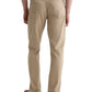 A person is shown from the back, standing against a plain white background, wearing AG Jeans' Everett Slim Straight beige jeans with a classic five-pocket design, paired with a white shirt and brown shoes.