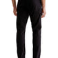 Man in black AG Jeans Everett Sueded Stretch Sateen pants and white shoes standing with a side view.