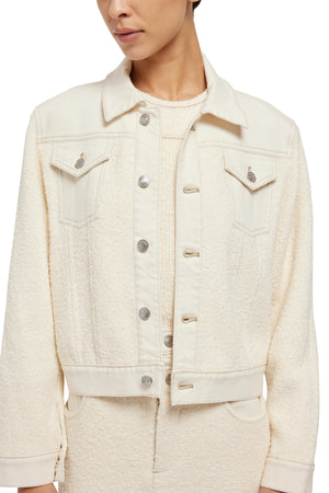 Woman wearing a cream-colored Simkhai sherpa jacket with button front closures, hand wash recommended.