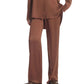 A person wearing the CO Elastic Silk Pant in brown with a matching long-sleeve shirt, styled with brown shoes.