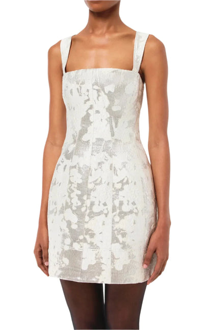 Person wearing the Simkhai Lydia Mini Dress, a sleeveless white and gray floral dress with a fitted design, square neckline, and decorative elements.