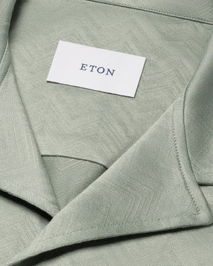 Close-up of the Eton Green Knitted Resort Shirt, featuring a textured light green fabric and visible white Eton label inside the collar, styled for an elevated look.
