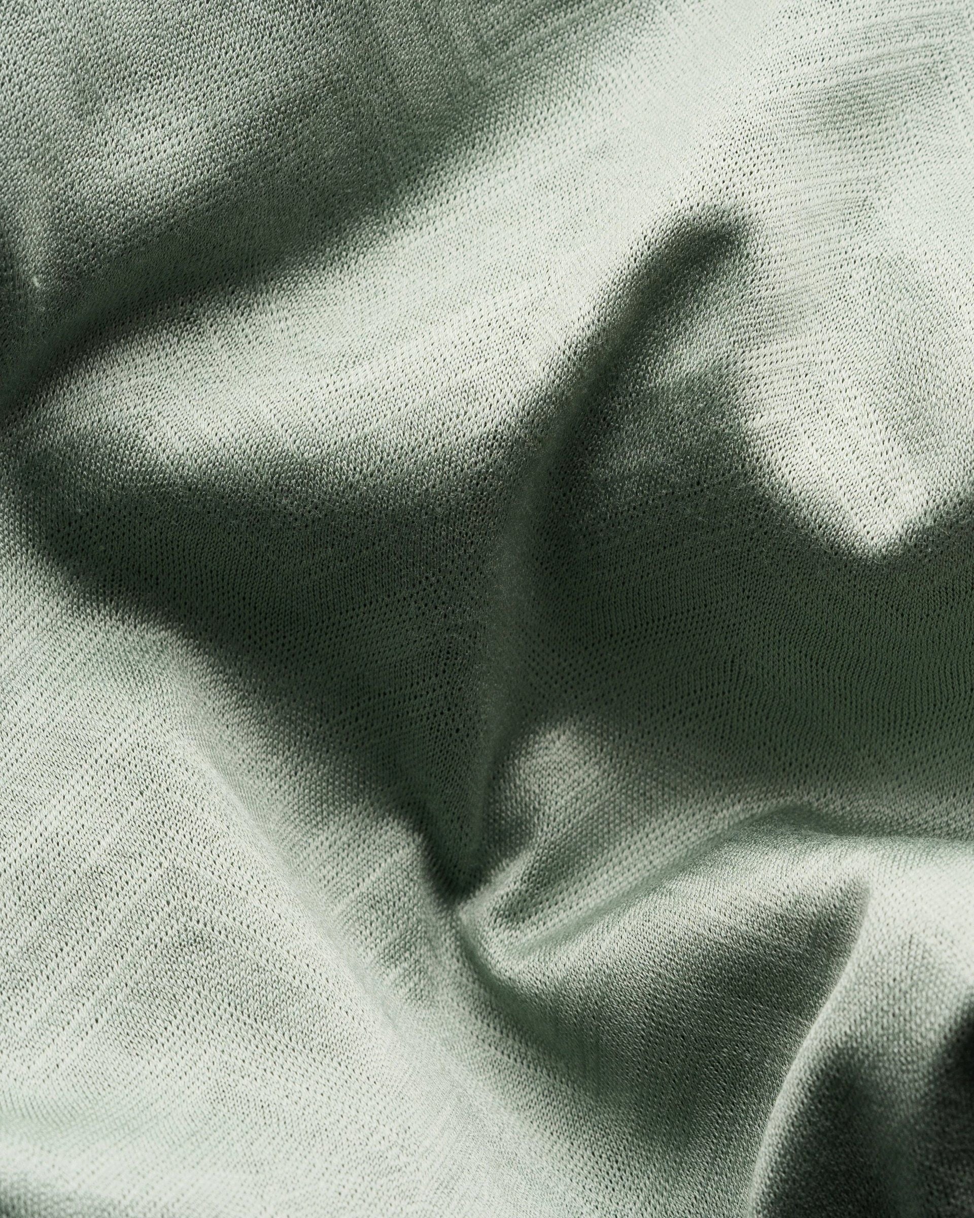 Close-up of the Green Knitted Resort Shirt by Eton, featuring light green interlock knit fabric with a visible woven texture and gentle folds for a soft, elegant feel.