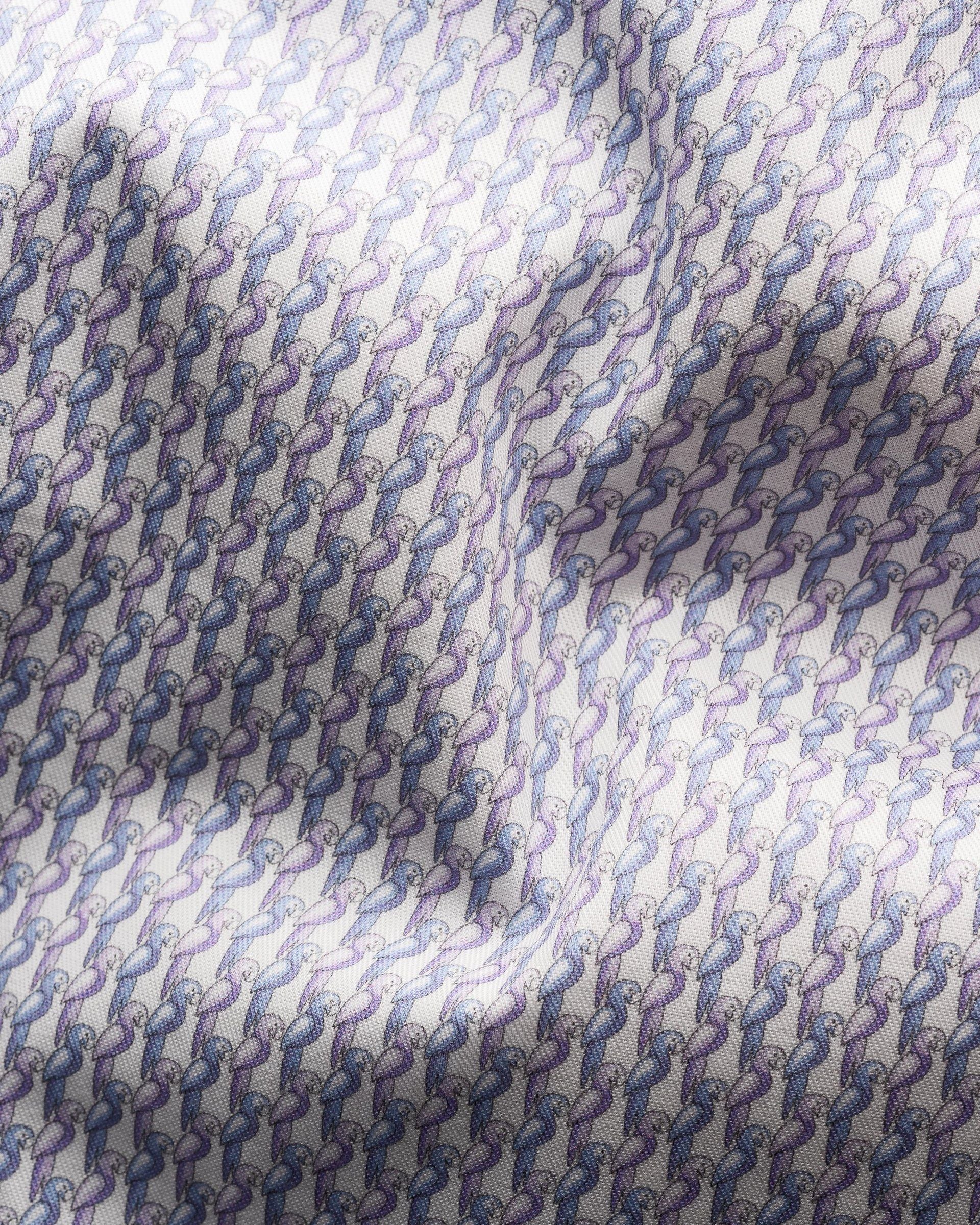 A close-up of Eton's Cut Away Slim Signature Twill Parrot Shirt reveals a repeating geometric pattern in blue and lavender, crafted from extra long staple cotton. Light and shadow dance on its wrinkle-free surface, accentuating its luxurious texture.