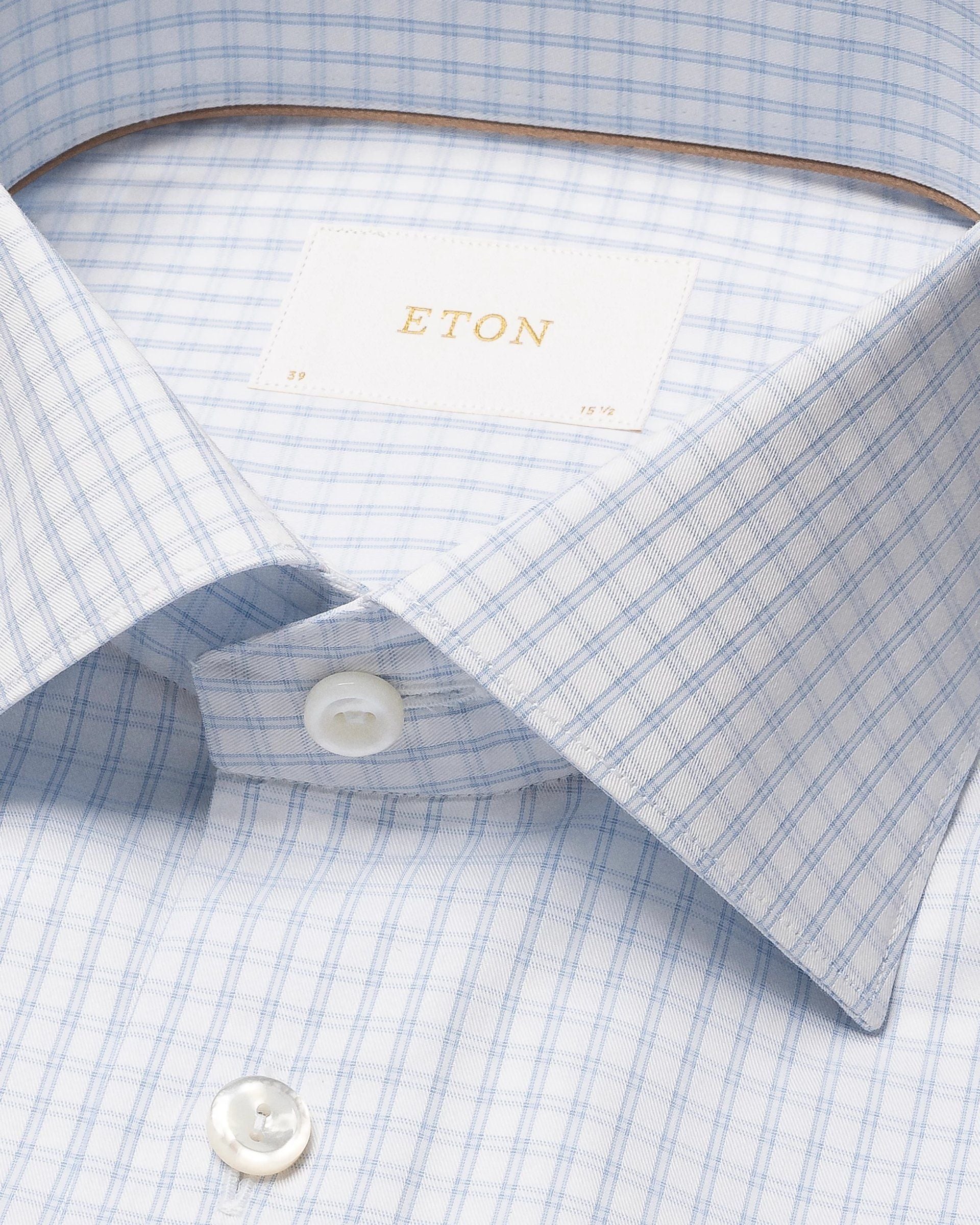 Close-up of the Eton Light Blue Check Signature Twill Cut Away Contemporary Shirt, showcasing crisp fabric, a white button, and brand label inside the collar—ideal for a sharp, wrinkle-free business look.