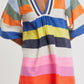 Wearing the Lemlem Belkis Caftan—a short, hand-woven multicolored dress with a deep V-neck and wide sleeves—brings effortless bohemian flair.