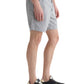 Someone wears the AG Jeans Cipher Short in white seersucker with thin vertical stripes, paired with black sneakers, standing against a white background.