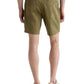 A person is shown from the back wearing AG Jeans’ Oliver Short in olive green, featuring an adjustable drawstring waist, paired with a white t-shirt and beige sneakers.