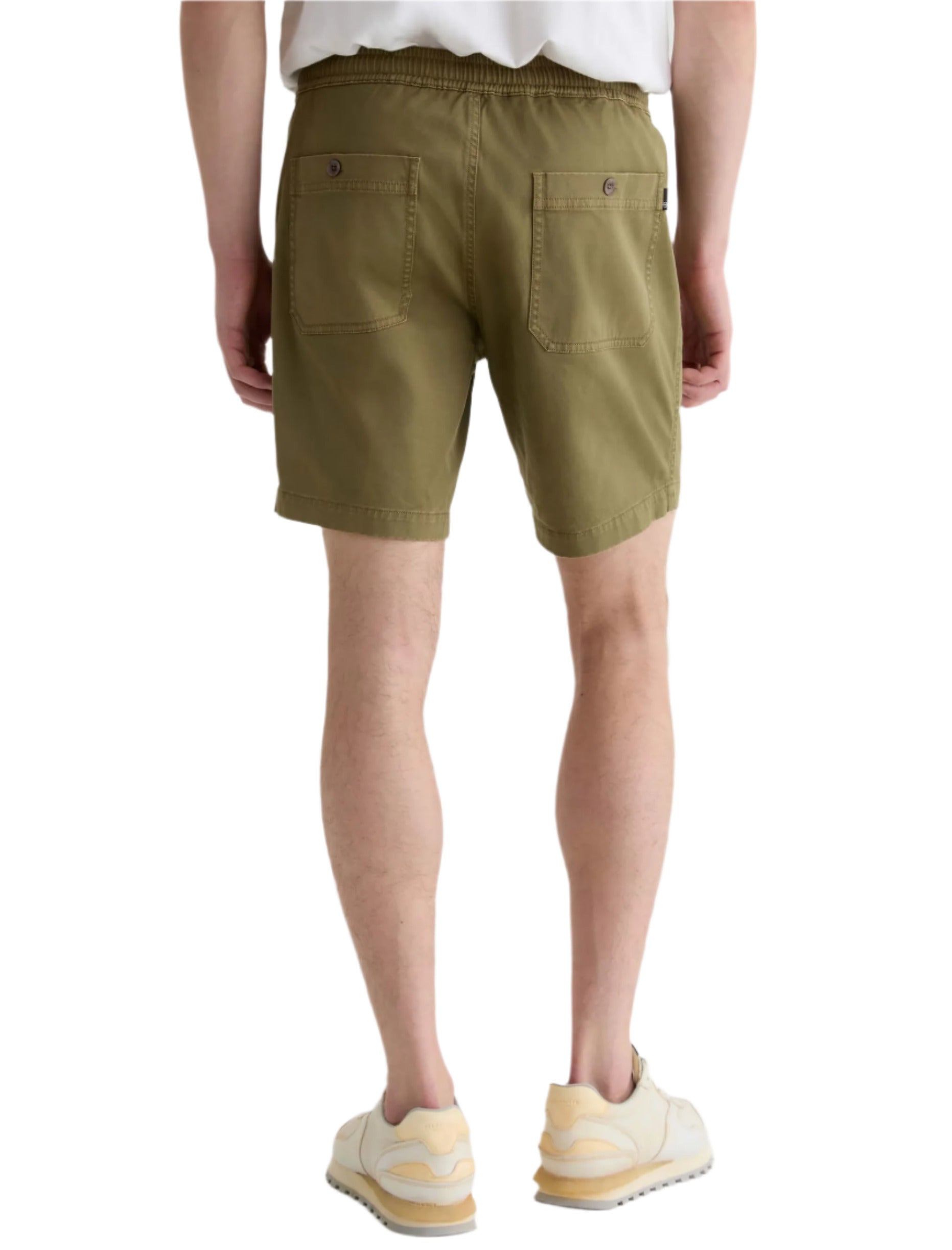 A person is shown from the back wearing AG Jeans’ Oliver Short in olive green, featuring an adjustable drawstring waist, paired with a white t-shirt and beige sneakers.