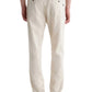 A person wearing AG Jeans' Tate Drawstring Pant in off-white twill linen, paired with a white shirt and brown shoes, viewed from the back.