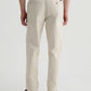 A person is shown from the back against a plain, light background wearing the Archie Sueded Trouser by AG Jeans in a light beige khaki color, paired with a dark shirt and brown shoes.
