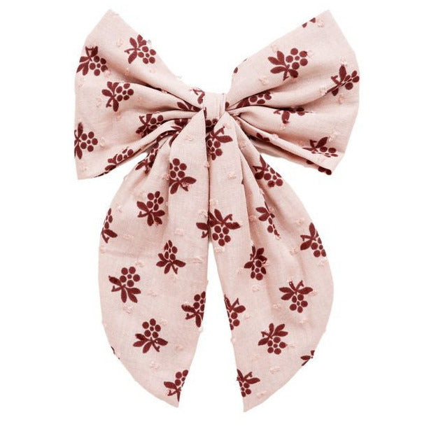 The Rylee & Cru Oversized Bow features pink fabric with maroon floral patterns, two long tails, and a central knot.