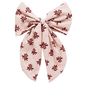 The Rylee & Cru Oversized Bow features pink fabric with maroon floral patterns, two long tails, and a central knot.