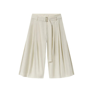 CO’s Pleated Culotte features wide legs, front pleats, a matching fabric belt, and comes in light beige, shown against a white background.