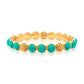 The Juliska Capucine De Wulf Berry Gem Hinged Bangle features alternating round turquoise gems and textured golden berries, pictured against a white background.