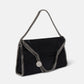 The Falabella Fold Over Tote by Stella McCartney is a black envelope-style vegan bag with chain edges and strap, plus a round metallic charm. Crafted from recycled plastic bottles, it's inspired by the iconic Falabella tote.