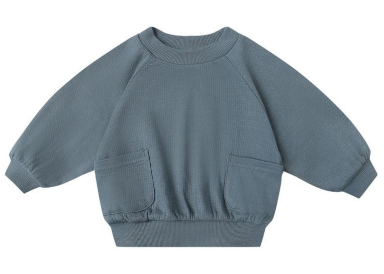 The Quincy Mae Baby Boys' and Boys' Pocket Sweatshirt in blue features long sleeves, two front pockets, ribbed cuffs, gathered sleeves, and a ribbed waistband, shown against a white background.