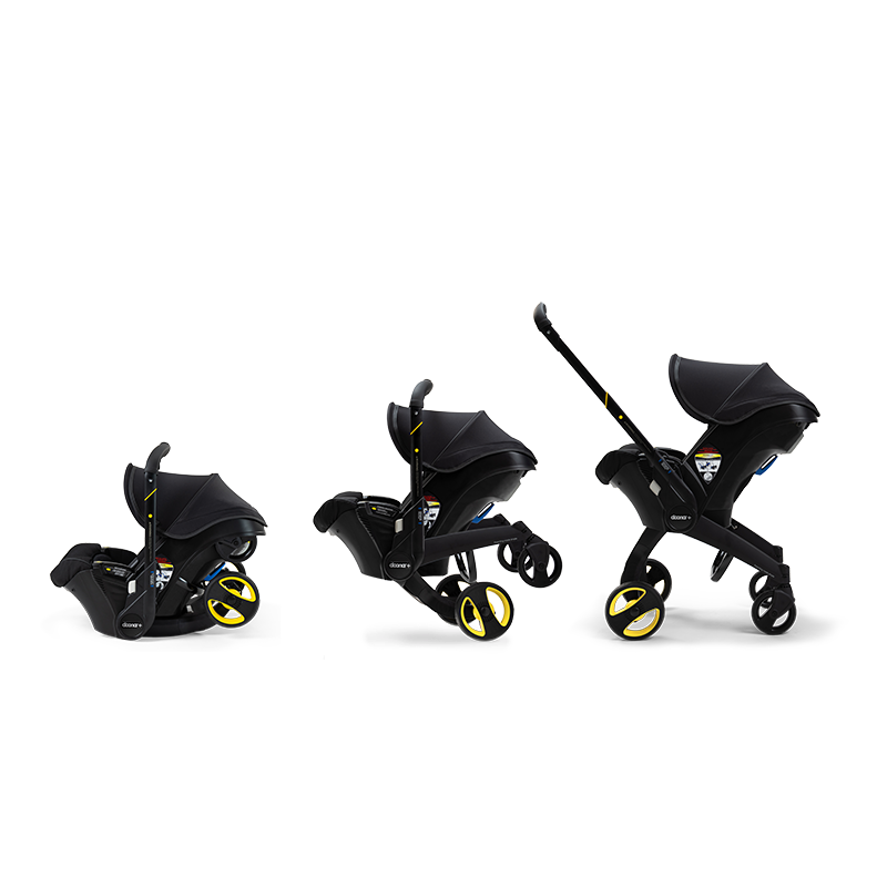 Three stages of the Doona Car Seat and Stroller, Midnight Edition by Doona in black and yellow: car seat stroller, semi-unfolded stroller, and fully unfolded stroller with handle extended.