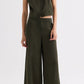 Person wearing TWP’s Rosen Green sleeveless top with the Demie Coated Viscose Linen Pant, standing against a plain light background.
