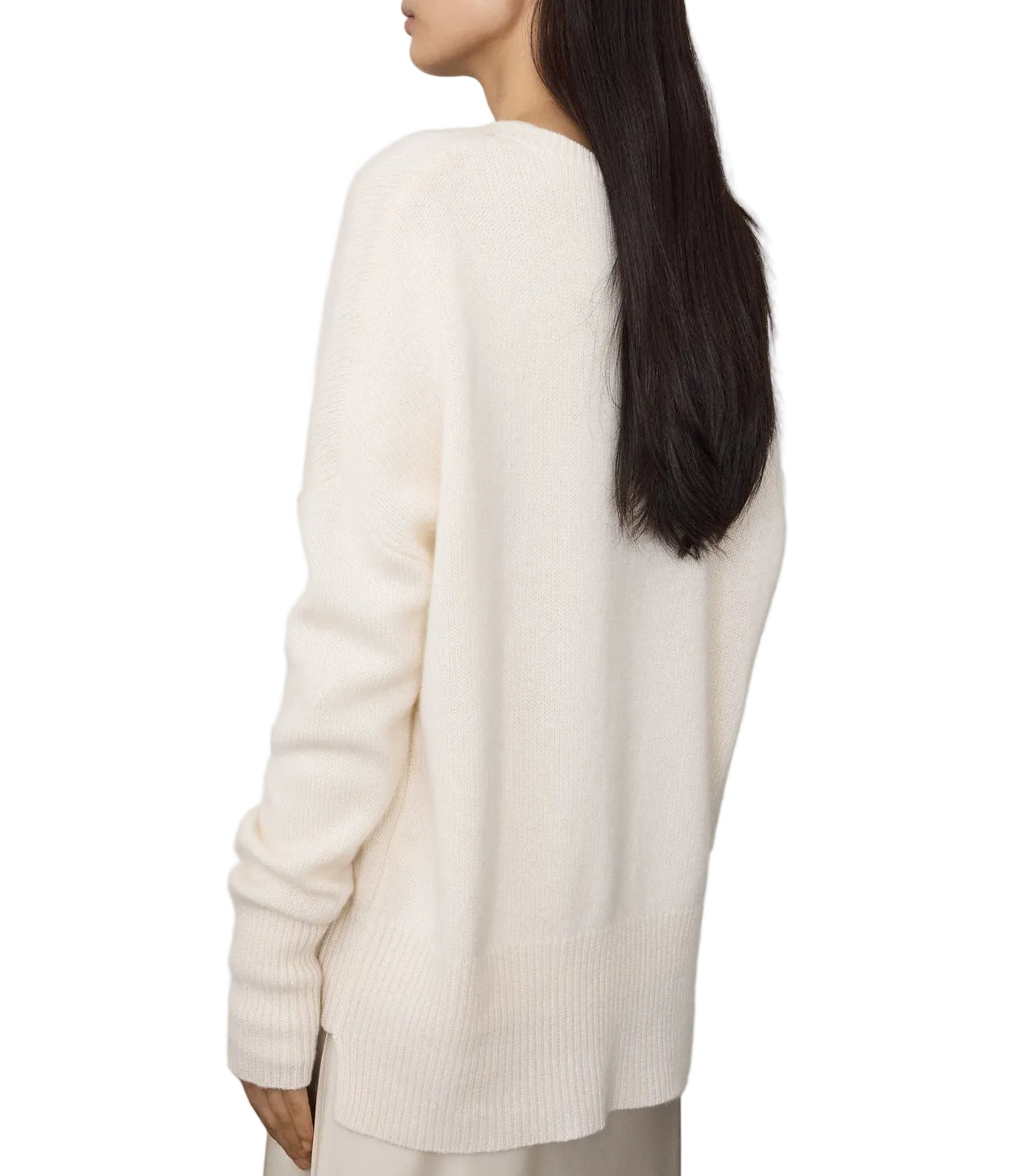 A woman with long dark hair models the Lisa Yang Mila Cashmere Sweater, an off-white, heavy knit crewneck with a relaxed fit, shown from the back against a plain white background.