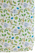 Timo & Violet's Crib Sheet features soft white fabric with yellow monkeys hanging from green vines, surrounded by green and blue leaves—perfect breathable bedding for your little one.