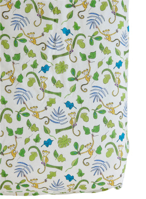 Timo & Violet's Crib Sheet features soft white fabric with yellow monkeys hanging from green vines, surrounded by green and blue leaves—perfect breathable bedding for your little one.