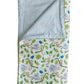 The Timo & Violet Crib Quilt is reversible, with a blue and white striped underside and a top featuring monkeys and leaves in green, blue, and yellow.