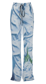 Victoria Beckham's pleat detail pyjama trouser in light blue silk features a wide leg, drawstring waist, and delicate floral print near the lower leg.