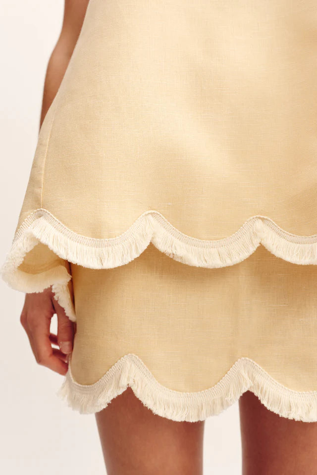 A close-up of a person wearing the POSSE Essie Top. Only the lower body and part of one hand are visible.