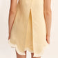 A person is photographed from behind wearing the POSSE Essie Top, a sleeveless, light yellow piece with a scalloped hem and a square neckline.