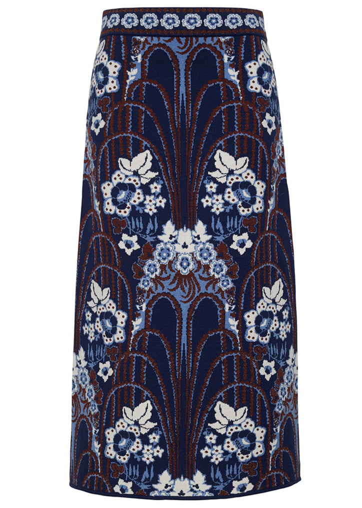 The Clara Skirt by Cara Cara is a high-waisted midi sheath featuring a blue, white, and brown floral and arch jacquard pattern on a dark background.