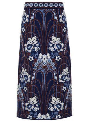 The Clara Skirt by Cara Cara is a high-waisted midi sheath featuring a blue, white, and brown floral and arch jacquard pattern on a dark background.