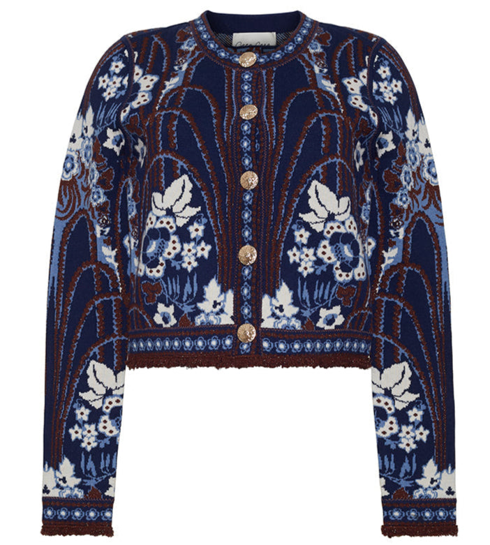 The Livi Jacket by Cara Cara is a navy blue, long-sleeved jacquard knit cardigan featuring white and brown floral and leaf patterns, finished with gold decorative buttons.