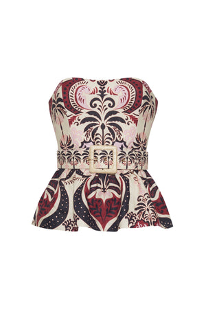The Tilda Top by Cara Cara is a strapless peplum style with boning for structure, a belted waist with square buckle, and an ornate red, black, and cream pattern.