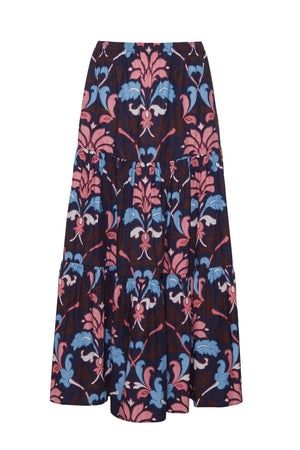 The Melanie Skirt by Cara Cara features a long, tiered poplin silhouette with a dark background and bold pink and blue floral patterns.