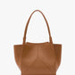 The Small Victoria Tote by Victoria Beckham, made from smooth tan calf leather, features two long handles and a minimalist design, displayed on a plain white background.