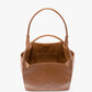 The Small Victoria Tote by Victoria Beckham, made from smooth tan calf leather, has two handles, an open top, and an interior pocket, shown against a white background.