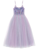 The Girls’ Goodspell Glimmer Tutu Dress by Tutu du Monde features delicate thin straps, a fitted sequin bodice adorned with blue and purple beaded accents, and a full, floor-length lavender tulle skirt. This enchanting design beautifully captures the essence of a classic purple tutu dress with its elegant and striking details.