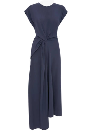 The Victoria Beckham Aria Twist Waist Dress is a sleeveless navy blue midi in luxe crepe back satin, with a round neckline and an asymmetrical draped knot at the waist for an Eclipse-inspired look.