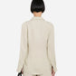 A person with short, straight black hair wears the CO Fitted Collared Shirt in light beige, paired with matching pants. They are standing with their back to the camera against a plain background.