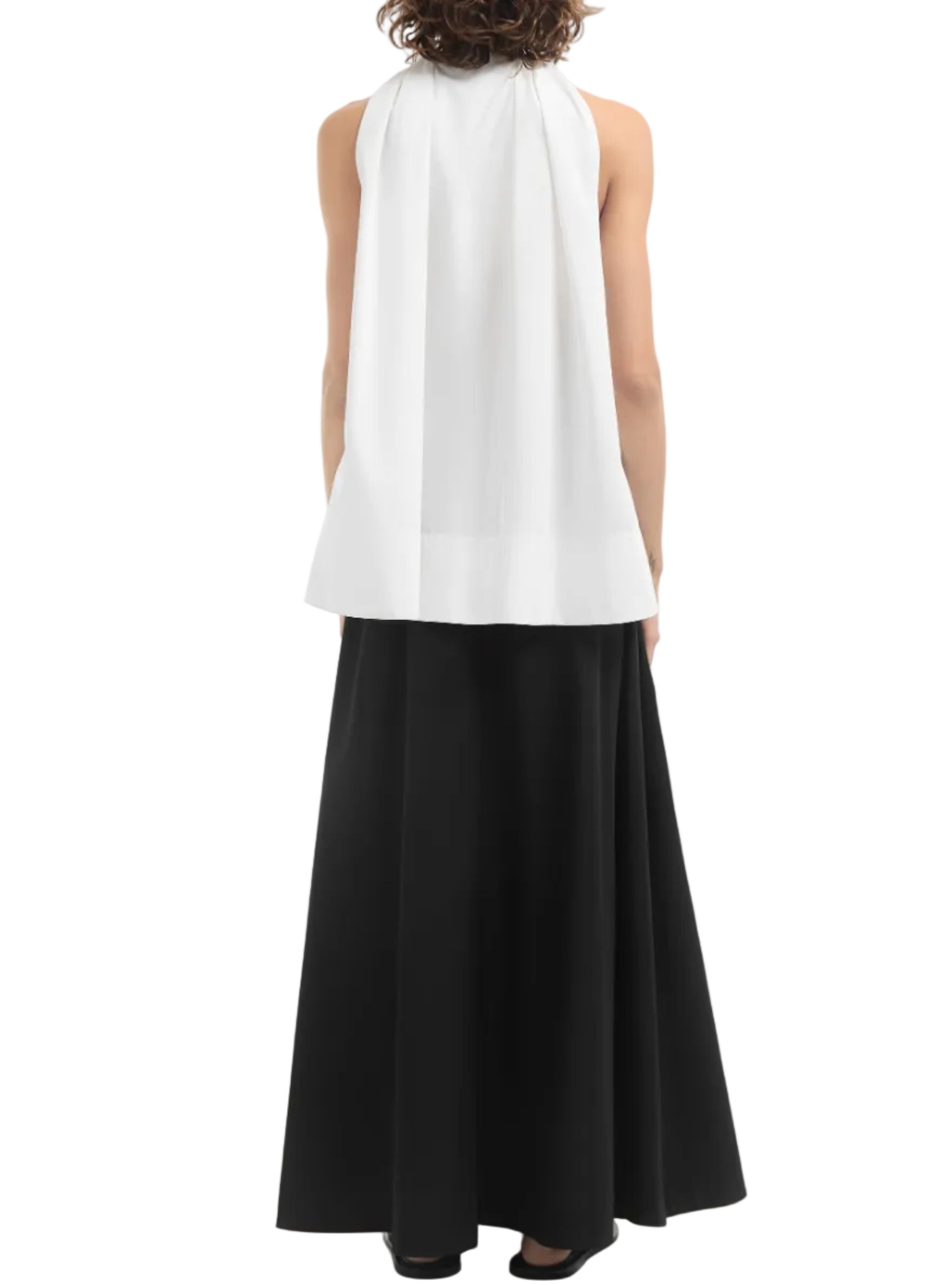 A person wearing the CO Gathered Tunic Shirt and a long black skirt stands facing away from the camera against a plain background.