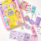The Super Smalls Create Your Own Body Lotion kit is displayed with lotion tubes, jars, stickers, mixing tools, and an instruction booklet laid out on a white surface. This DIY kit allows kids to safely mix and decorate their own body lotions for a fun and educational beauty activity.