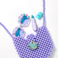 The Super Smalls Mermaid Dreams Handbag, paired with glittery blue lipstick and gem-studded round sunglasses, is stylishly displayed on a white background.